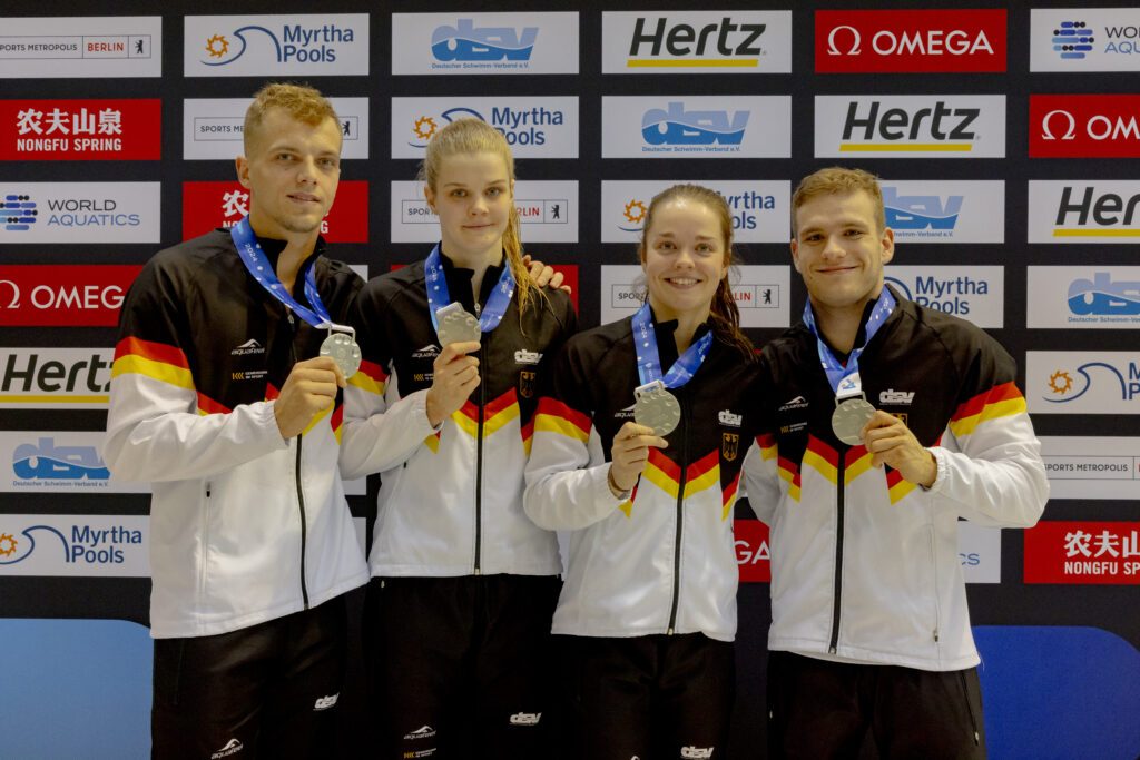 Die deutschen Wasserspringer*innen Timo Barthel, Christina Wassen, Saskia Oettinghaus und Moritz Wesemann zeigen ihre Silbermedaillen aus dem Team-Event beim Weltcup in Berlin