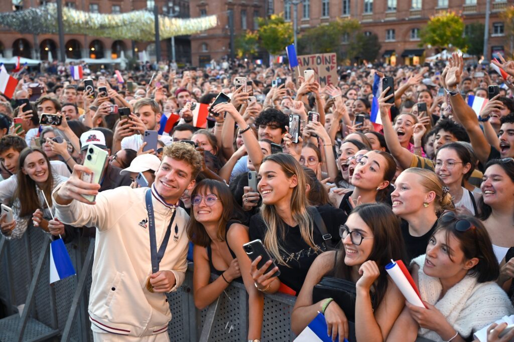 Léon Marchand wird nach seinen Olympiaerfolgen von den Fans umschwärmt. Hier macht ein Selfie mit ihnen