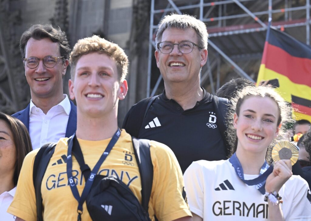 DOSB-Chef Thomas Weikert (2.v.r.) bei der Rückkehr aus Paris mit den Olympiasieger*innen Lukas Märtens und Darja Varfolomeev