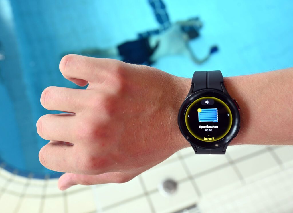 Im Panorama-Bad in Freudenstadt wird eine Smartwatch gezeigt, mit der es durch eine KI-gestützte Videoüberwachung möglich sein soll zu erkennen, wenn z.B. ein Becken überfüllt ist, ein Kind ohne Schwimmflügel sich dem Beckenrand nähert oder ein Körper 20 Sekunden unter Wasser ist.