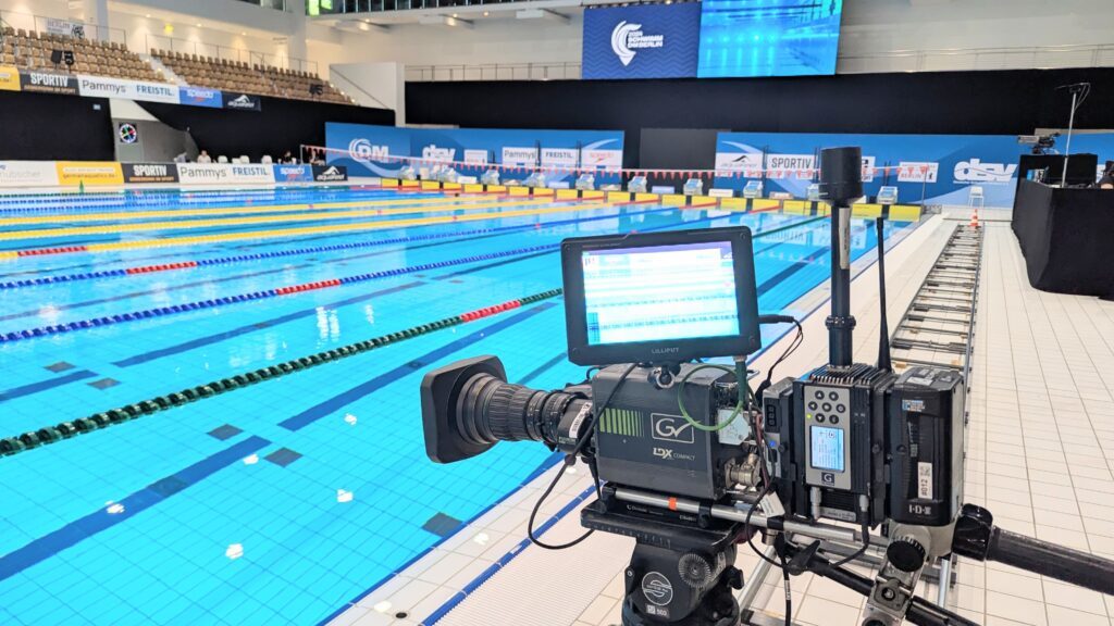 Eine Fernsehkamera ist bei der Schwimm-DM 2025 in Berlin auf das Wettkampfbecken gerichtet