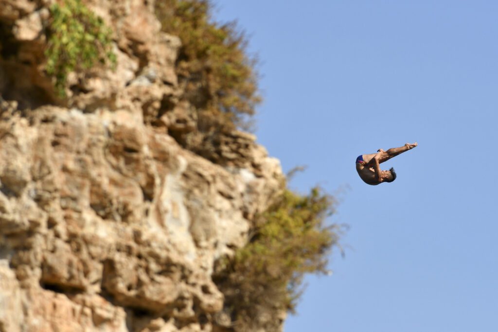 Ein High Diver vor einer spektakulären Klippenkulisse