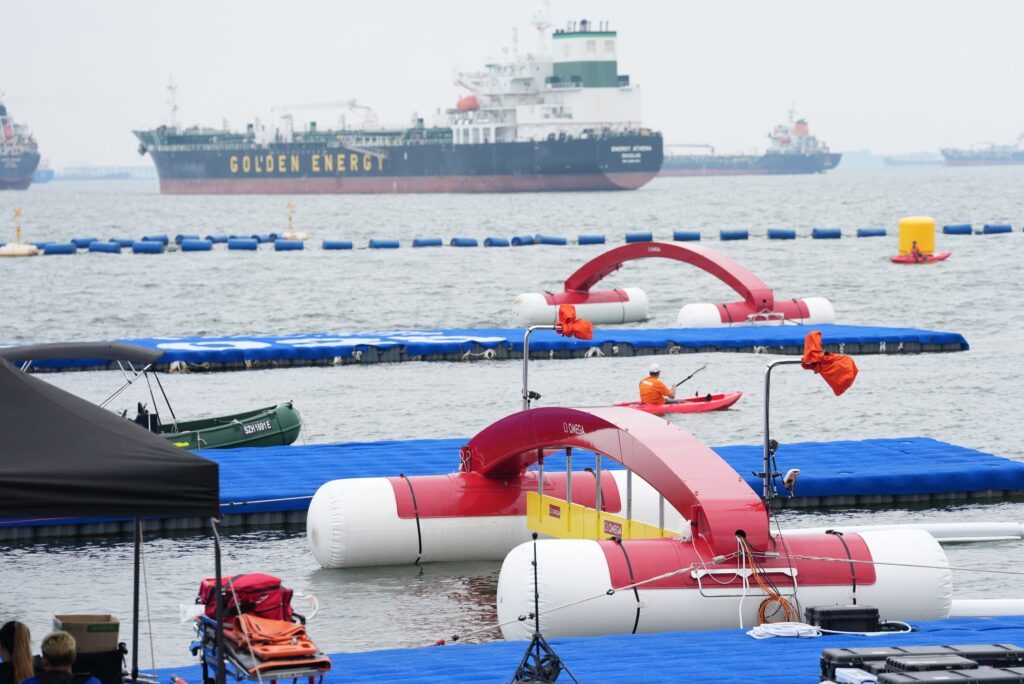 Blick auf den Start-Ziel-Bereich der Freiwasserrennen bei der Schwimm-WM 2025 in Singapur, im Hintergrund ist ein großer Tanker zu essen
