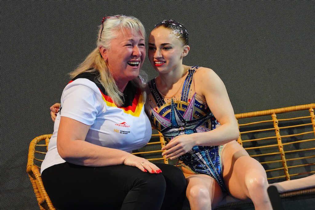 Synchronschwimmerin Klara Bleyer aus Deutschland und ihre Trainerin Stella Mukhamedova freuen sich nach der Punktevergabe der Jury über die Goldmedaille in der Freien Kür des Solowettbewerbs bei der EM 2025 in Funchal
