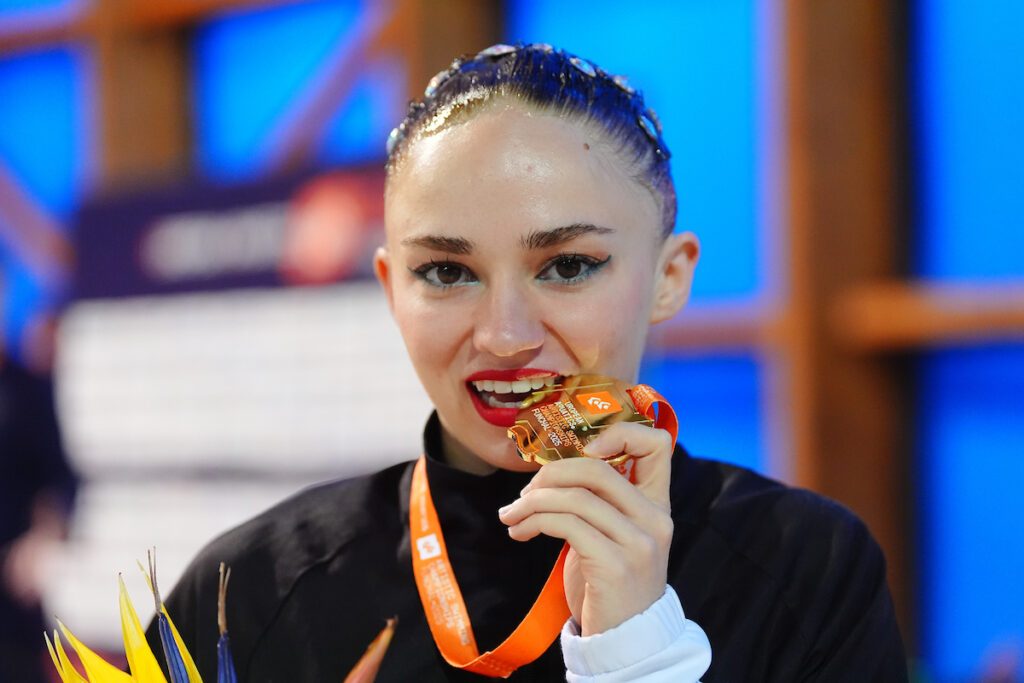Synchronschwimmerin Klara Bleyer beißt in ihre EM-Goldmedaille aus dem Solowettbewerb bei der EM 2025 auf Madeira