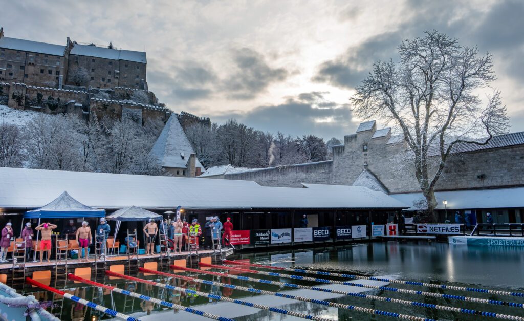 Eisschwimmer kurz vor dem Start bei den Burghausen Open, im Hintergrund ist die Burg von Burghausen zu sehen