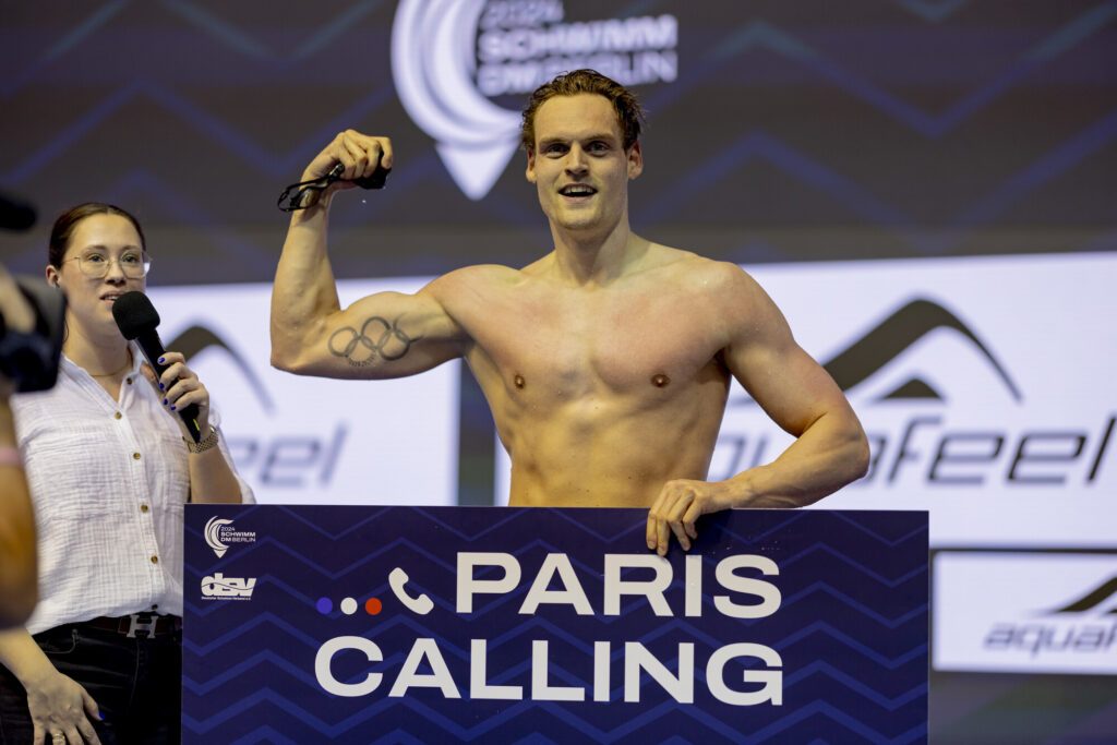 Schwimmer Marek Ulrich ballt bei den Deutschen Meisterschaften 2024 nach erfüllter Olympianorm die Faust und hält ein Schild mit dem Schriftzug "Paris Calling"