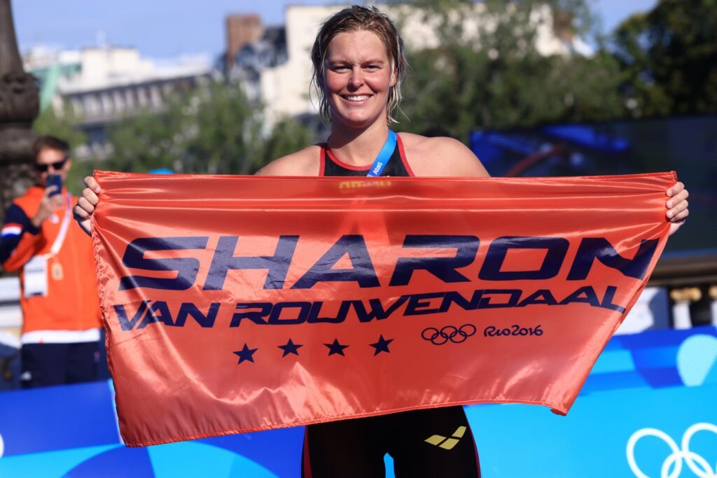 Freiwasserschwimmerin Sharon van Rouwendaal aus den Niederlanden posiert bei den Olympischen Spielen 2024 in Paris mit einer Fahne mit ihrem Namen
