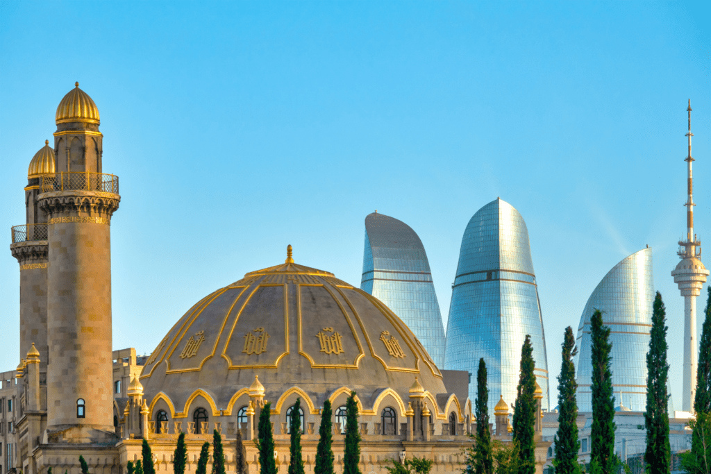 Stadtpanorama von Aserbaidschans Hauptstadt Baku mit einer Moschee im Vordergrund und modernen Hochhäusern im Hintergrund