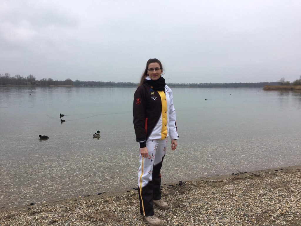 Eisschwimmerin Alisa Fatum-Böker aus Deutschland steht im Herbst in warmen Klamotten am Ufer eines Sees