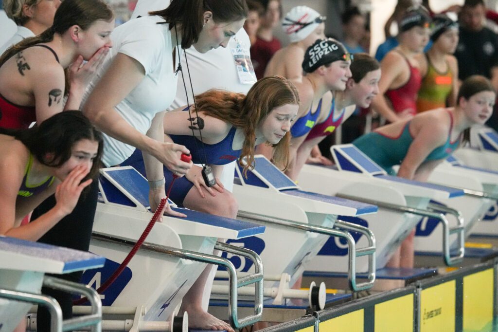 Schwimmerinnen feuern beim DMSJ-Bundesfinale vom Beckenrand aus ihre Teamkolleginnen im Becken an