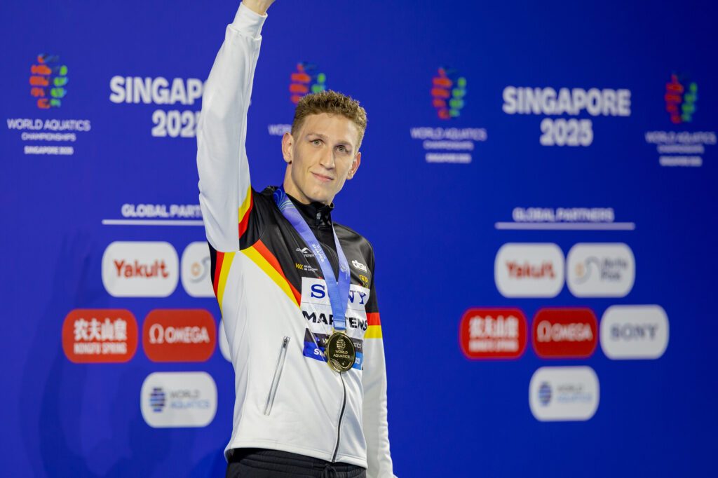 Schwimmer Lukas Märtens aus Deutschland winkt bei der Siegerehrung der WM 2025 in Singapur mit der Goldmedaille um den Hals