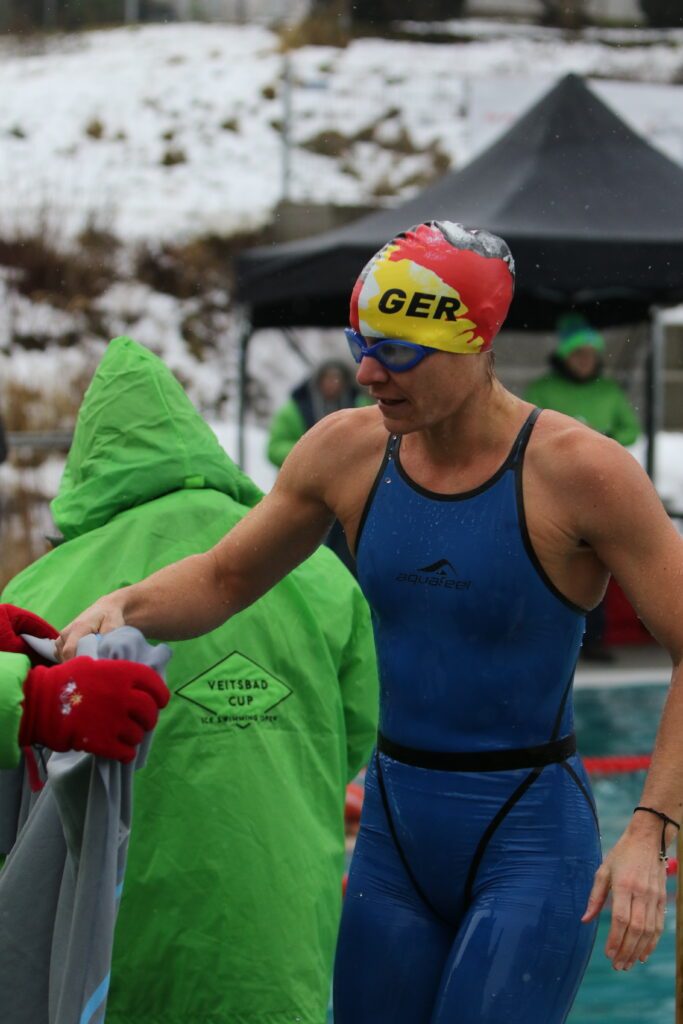 Eisschwimmerin Franziska Partheymüller lässt sich beim Deutschland-Ice-Cup in Veitsbronn 2026 direkt nach dem Wettkampf ein wärmendes Handtuch reichen