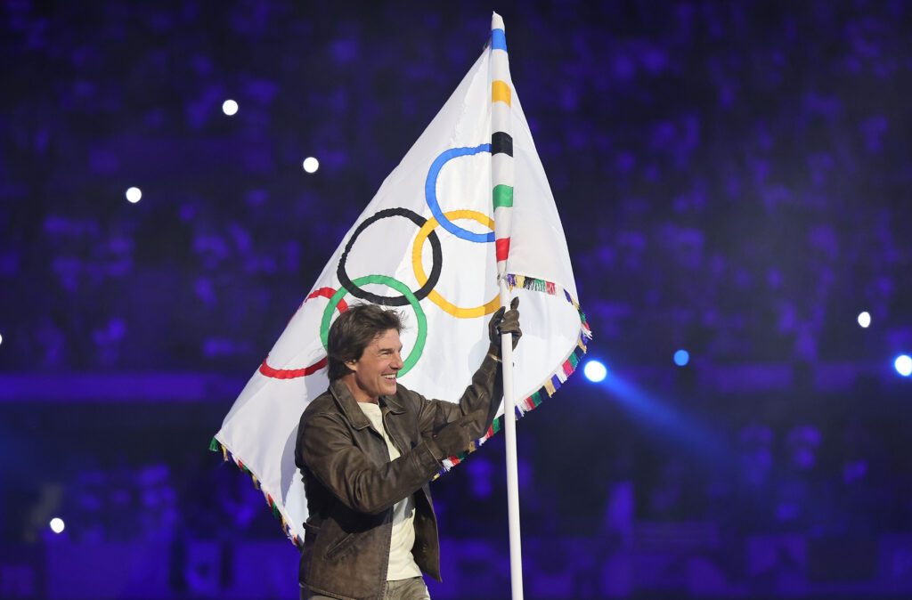 Hollywood-Star Tom Cruise trägt bei der Abschlussfeier der Olympischen Sommerspiele 2024 in Paris die olympische Fahne, die an den nächsten Gastgeber Los Angeles weitergereicht wurde