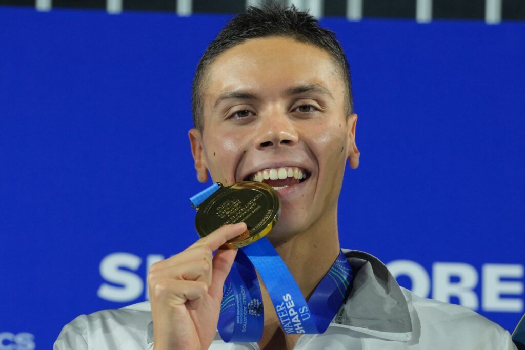 Schwimmer David Popovici aus Rumänien beißt nach seinem WM-Sieg 2025 in Singapur in seine Goldmedaille