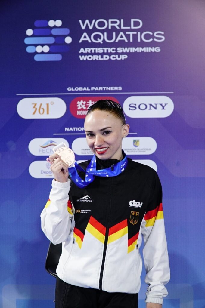 Synchronschwimmerin Klara Bleyer hält beim Weltcup 2026 in Medellin in Kolumbien ihre Bronzemedaille aus der Technischen Kür des Solowettbewerbs in die Kamera