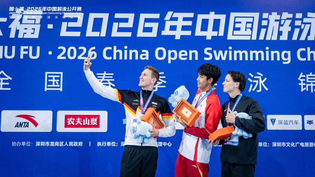 Schwimmer Lukas Märtens aus Deutschland macht bei den China Open 2026 ein Selfie auf dem Siegerpodest mit den weiteren Medaillengewinnern Zhang Zhanshuo und William Petric