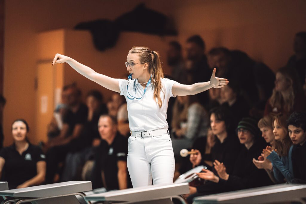 Wasserball-Schiedsrichterin Paula Riehn aus Deutschland am Beckenrand mit Pfeife im Mund