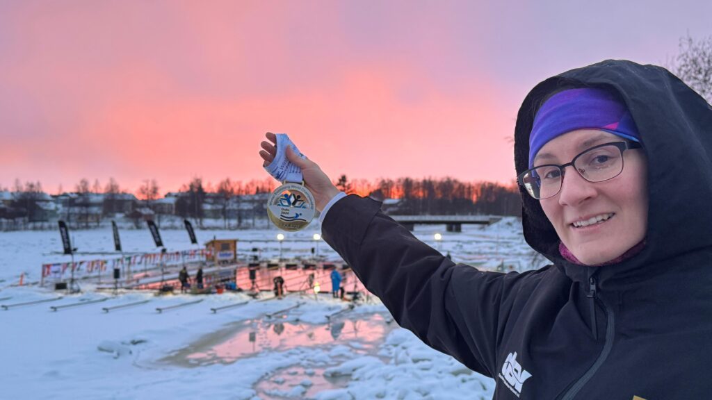 Eisschwimmerin Alisa Fatum-Böker aus Deutschland hält eine Medaille in die untergehende Abendsonne bei der Eisschwimm-WM 2026 in Oulu