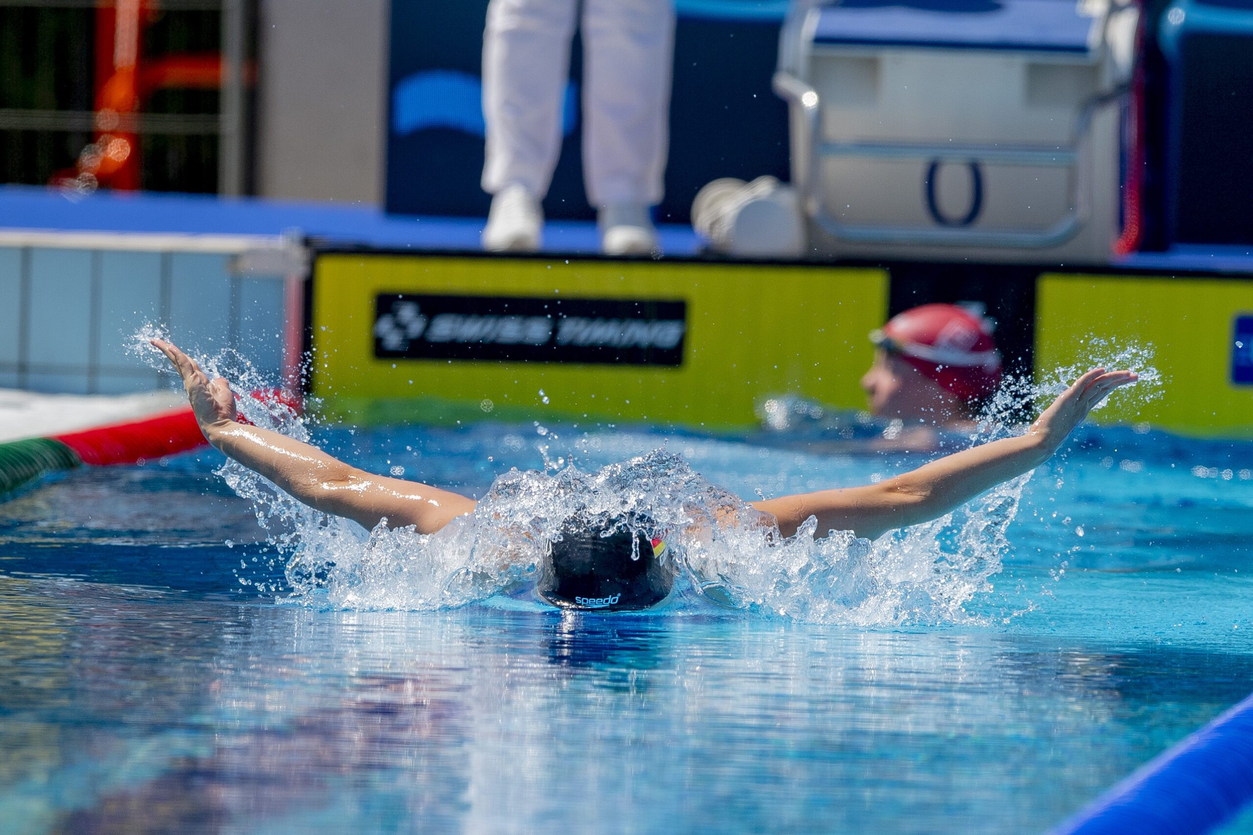 Eine Schwimmerin schwimmt beim Wettkampf im Freibad Schmetterling