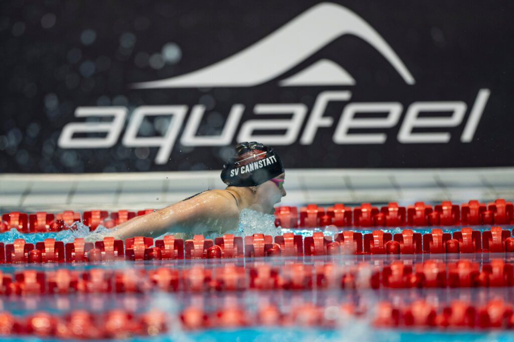 Anna Rutz vom SV Cannstatt schwimmt bei den Deutschen Jahrgangsmeisterschaften im Schwimmen 2025, im Hintergrund ein Banner mit dem Banner des Ausrüsters Aquafeel