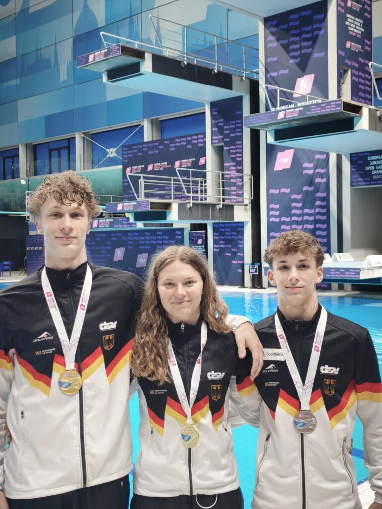 Finn Awe, Emily Deml und Louis Aaron Förster zeigen stolz ihre Medaillen von der Junioren-EM 2026 in Budapest