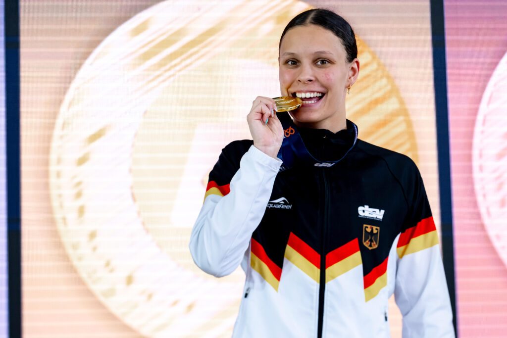 Schwimmerin Linda Roth aus Magdeburg beißt in ihre Goldmedaille bei der JEM 2026 in München