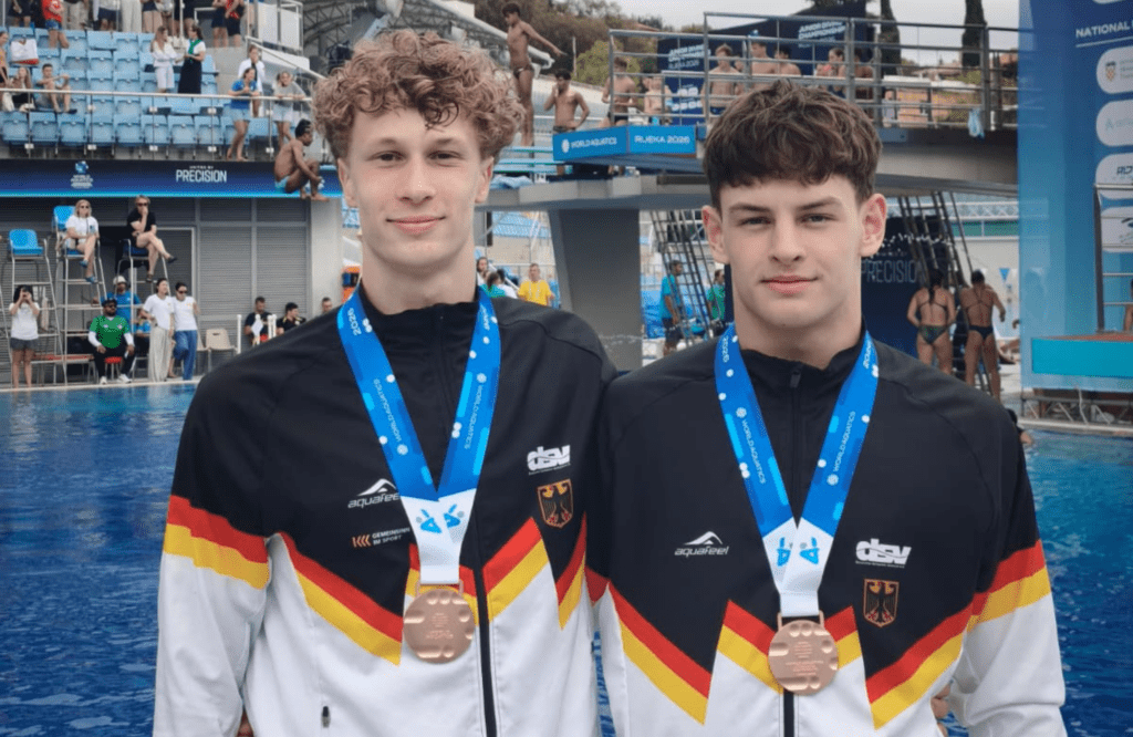 Die Wasserspringer Finn Awe und William Ackmann aus Deutschland zeigen ihre Bronzemedaillen aus dem 3m-Synchronwettbewerb bei der Junioren-WM 2026 in Rijeka