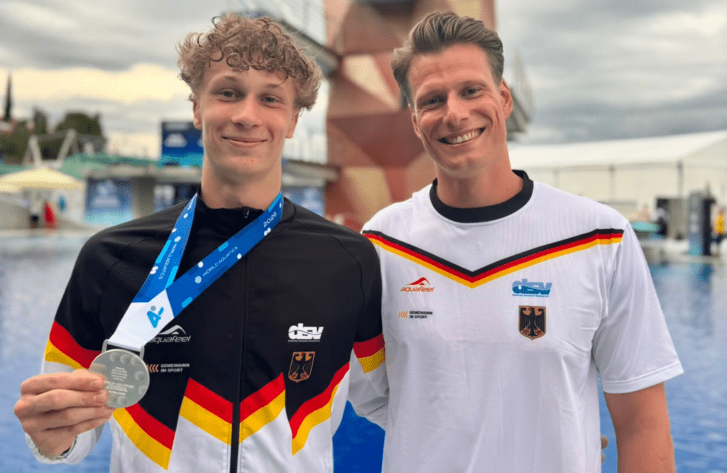 Wasserspringer Finn Awe aus Deutschland zusammen mit Trainer Lucas Orlowski, Awe zeigt seine Silbermedaille von der Junioren-WM 2026 vom 1m-Brett