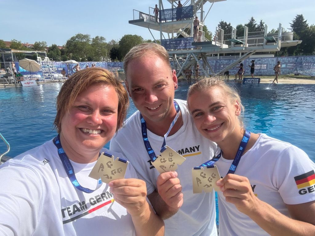 Drei Wasserspringer aus Deutschland präsentieren ihre Goldmedaillen von der Masters-EM 2026 in Graz
