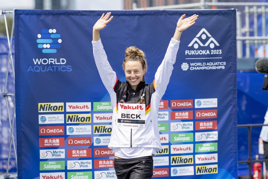 Freiwasserschwimmerin Leonie Beck aus Deutschland winkt bei der WM 2023 in Fukuoka vor der Siegerehrung ins Publikum