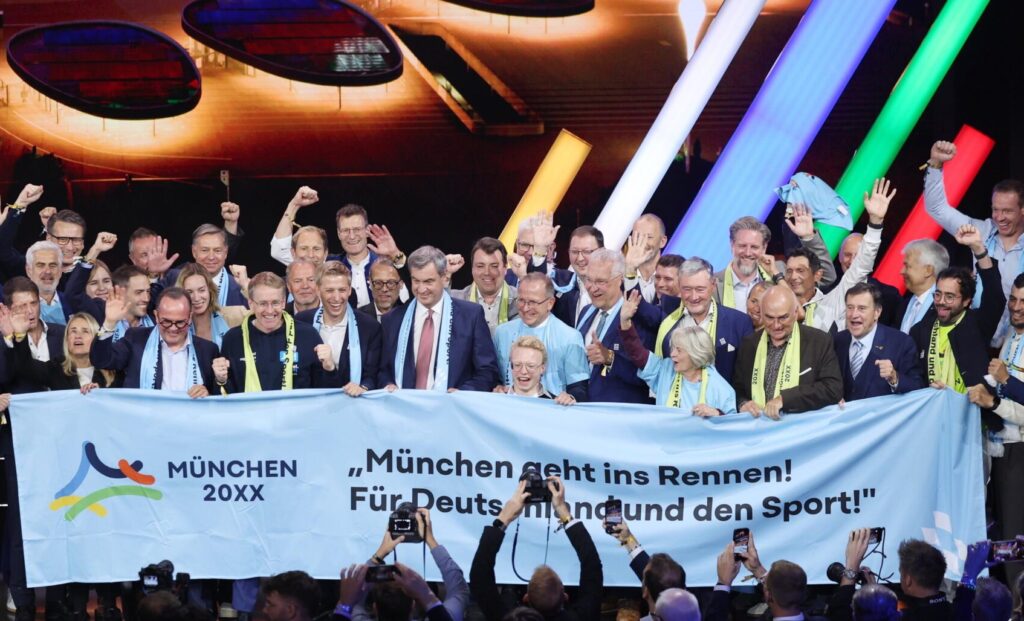 Münchens Delegation mit Bürgermeister Dominik Krause und Ministerpräsident Markus Söder feiert den Wahlsieg