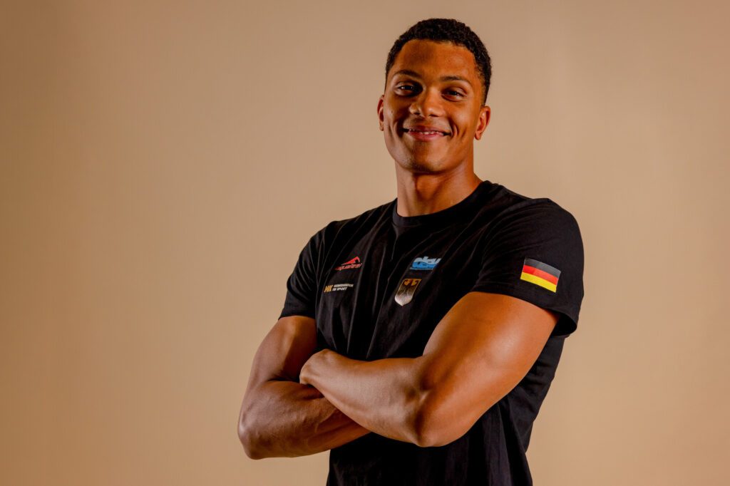 Schwimmer Melvin Imoudu aus Potsdam posiert mit vor der Brust verschränkten Armen in der Kleidung der Nationalmannschaft beim Media Day im Rahmen der Deutschen Meisterschaften 2026 in Berlin
